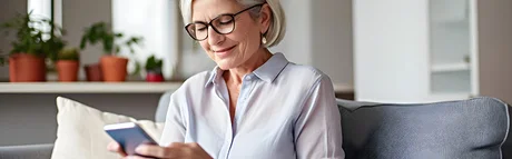 Frau liest auf ihrem Smartphone OM-Komplett